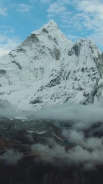 Nangartsang Zirvesinde Ama Dablam Dağı 'na bakan adam. Himalaya, Nepal. Hava görüntüsü. Drone geriye doğru uçuyor. Dikey Video
