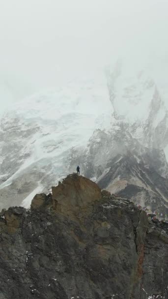 Kala Patthar山顶上的远足者观摩Khumbu Icefall Everest和Nuptse 尼泊尔喜马拉雅 空中景观 飞行员向前飞 垂直录像 — 图库视频影像