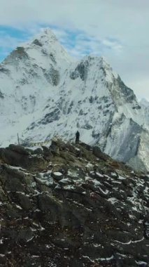 Yürüyüşçü Adam ve Ama Dablam Dağı. Himalaya, Nepal. Hava görüntüsü. Drone yörüngede. Dikey Video