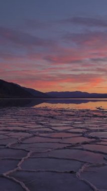 Sunset 'teki Badwater Havzası. Tuz Kabuğu ve Gökyüzü Yansıması. Death Valley Ulusal Parkı. Kaliforniya, ABD. Döndürme atışı. Dikey Video