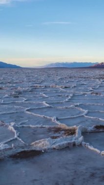 Güneşli günde Badwater Havzası. Tuz Kabuğu oluşumları ve Bulutlu Mavi Gökyüzü. Death Valley Ulusal Parkı. Kaliforniya, ABD. Zaman Hızı Yükseliyor. Dikey Video