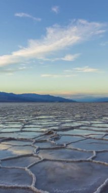 Sunset 'teki Badwater Havzası. Tuz kabuğu ve bulut yansıması. Death Valley Ulusal Parkı. Kaliforniya, ABD. Hızlandırılmış Panning Zaman Hızı. Dikey Video