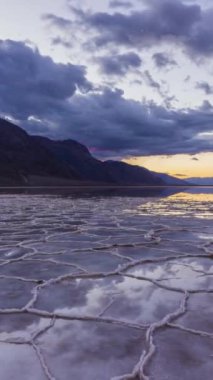 Gündoğumunda Badwater Havzası. Tuz kabuğu ve bulut yansıması. Death Valley Ulusal Parkı. Kaliforniya, ABD. Hızlandırılmış Panning Zaman Hızı. Dikey Video