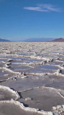 Güneşli günde Badwater Havzası. Tuz Kabuğu oluşumları ve Mavi Gökyüzü. Death Valley Ulusal Parkı. Kaliforniya, ABD. Eğil. Dikey Video