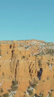 Kış gününde Red Canyon Serserileri. Dixie Ulusal Ormanı. Mavi Gökyüzü. Utah, ABD. Hava görüntüsü. Drone yörüngede. Dikey Video