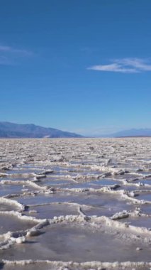 Güneşli günde Badwater Havzası. Tuz Kabuğu oluşumları ve Mavi Gökyüzü. Death Valley Ulusal Parkı. Kaliforniya, ABD. Çeviriyorum. Dikey Video
