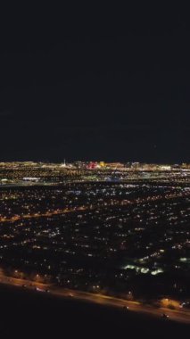 Gece vakti Las Vegas Skyline. Nevada, ABD. Hava görüntüsü. İnsansız hava aracı yandan uçuyor. Dikey Video