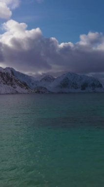 Haukland Sahili, Creek ve Dağları. Lofoten Adaları, Norveç Denizi, Norveç. Hava görüntüsü. Drone geriye doğru uçuyor. Dikey Video