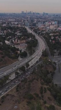 Sabah Los Angeles Skyline 'da. Highway 'de trafik vardı. Kaliforniya, ABD. Hava görüntüsü. Hollywood Tepelerinden Manzara. Drone İleri Uçuyor, Eğil. Şutu göster. Dikey Video