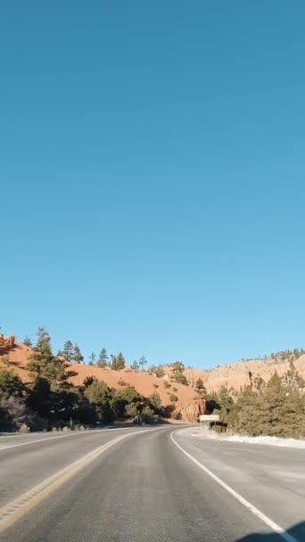 冬の晴れた日にレッドキャニオンを通って道路を運転する車 ディクシー国立森 アメリカ合衆国ユタ州 バーティカルビデオ — ストック動画