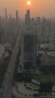 Shenzhen Şehri, Sunset 'te. Çin. Hava görüntüsü. Drone İleri Uçuyor, Eğil. Şutu göster. Dikey Video