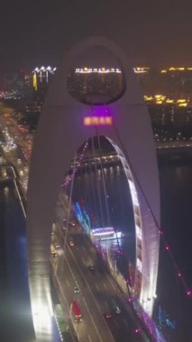 Gece Pearl River 'daki Liede Köprüsü. Guangzhou Şehri, Çin. Hava görüntüsü. Drone yörüngede. Dikey Video