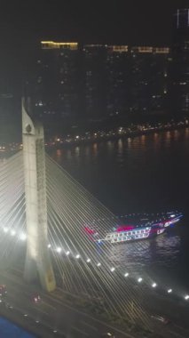 Guangzhou 'daki köprü, geceleri araba trafiği. Guangdong, Çin. Hava görüntüsü. Drone yörüngede, yukarı doğru uçuyor. Dikey Video