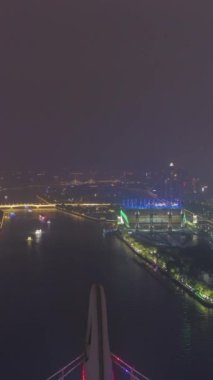 Liede Köprüsü ve Guangzhou Şehir Geceleri. Hava görüntüsü. Drone geriye doğru uçuyor. Dikey Video