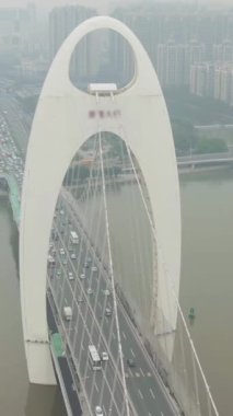 Pearl River 'daki Liede Köprüsü. Çin 'in Smog şehrindeki Guangzhou şehrinde. Hava görüntüsü. Drone saat yönünün tersine dönüyor. Dikey Video