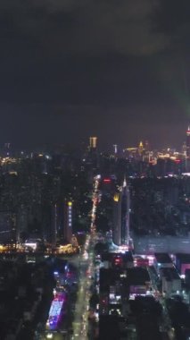 Gece vakti Shenzhen Şehir Şehri 'ni aydınlattı. Futian ve Luohu Bölgesi. Guangdong, Çin. İnsansız Hava Aracı Yana ve Aşağıya Uçar. Dikey Video