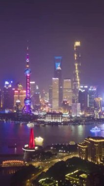 Gece Shanghai Skyline 'da. Şehir Lujiazui Bölgesi, Huangpu Nehri ve Waibaidu Köprüsü. Çin. Hava Hızı Hızı, Zaman Hızı. İnsansız hava aracı yukarı ve yana doğru uçuyor. Dikey Video