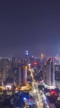 Shenzhen Şehri, Gece. Futian ve Luohu Bölgesi. Çin. Hava Hızı Hızı, Zaman Hızı. Drone Yana ve Yukarı Uçuyor. Dikey Video