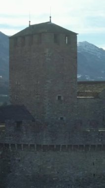 Montebello Kalesi. Bellinzona, Ticino, İsviçre. İsviçre Alpleri. Hava görüntüsü. İnsansız hava aracı yukarı doğru uçuyor, aşağı doğru eğiliyor. Dikey Video