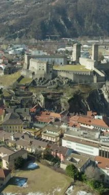 Castelgrande Kalesi. Bellinzona, Ticino, İsviçre. İsviçre Alpleri. Hava görüntüsü. İHA ileri uçuyor, geniş açıyla eğiliyor. Dikey Video