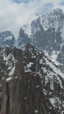 Tian Shan Karlı Dağları. Drone saat yönünün tersine dönüyor. Dikey Video