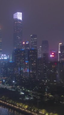 Liede Köprüsü ve Guangzhou Şehir Merkezi. Çin. Hava görüntüsü. İnsansız hava aracı geriye ve aşağıya uçuyor. Dikey Video