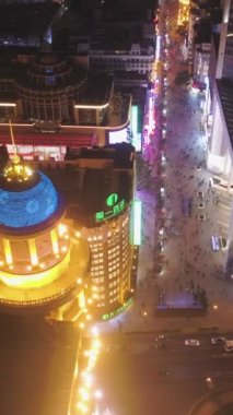 SHANGHAI, ÇİN - 20 Mart 2018 Gece Nanjing Yolu 'ndaki insanlar. Huangpu bölgesindeki yaya sokağı. Hava görüntüsü. İnsansız hava aracı yandan uçuyor. Dikey Video