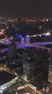 Gece Şangay 'da. Huangpu Şehri. Çin. Hava görüntüsü. Drone Yana ve Yukarı Uçuyor. Dikey Video