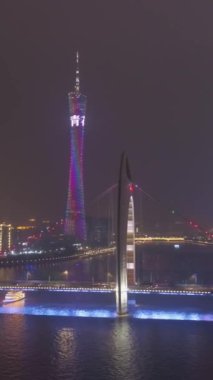 GuANGZHOU, ÇİN - 25 Mart 2018: Canton Tower ve Liede Bridge at Night. Guangzhou Şehri, Çin. Hava görüntüsü. Drone yörüngede. Dikey Video