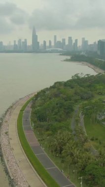 Shenzhen Şehri 'nde. Nanshan Bölgesi Şehir Merkezi ve Bay Park. Çin. Havadan İfşaat Çekimi. Drone İleri Uçuyor, Eğil. Dikey Video