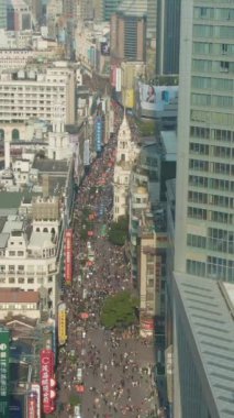 SHANGHAI, ÇİN - 20 Mart 2018 Nanjing Yolu. Huangpu bölgesindeki yaya sokağı. İnsanlar, kalabalık. Hava görüntüsü. İnsansız hava aracı yukarı doğru uçar, aşağı eğilir. Dikey Video