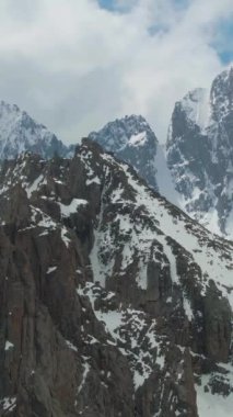 Tian Shan Karlı Dağları. Hava görüntüsü. Drone saat yönünde yörüngede. Dikey Video