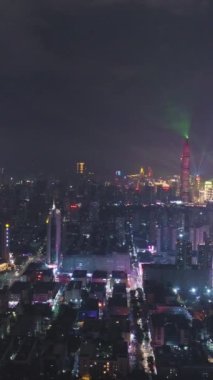 SHENZHEN, ÇİN - 30 Mart 2019: Işık Gösterisi Gecesinde Şehir Skyline 'ı aydınlattı. Futian ve Luohu Bölgesi. Guangdong 'da. Hava görüntüsü. Drone ileri ve aşağı uçuyor. Dikey Video