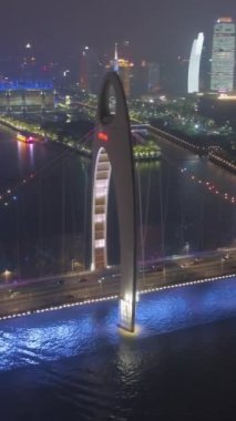 Pearl River 'daki Liede Köprüsü ve Guangzhou City' deki Gece manzarası. Çin. Hava görüntüsü. Drone yörüngede. Dikey Video