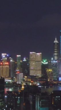 SHANGHAI, ÇİN - 20 Mart 2018 Shimao International Plaza ve Lujiazui Skyline at Night. Şangay, Çin. Hava görüntüsü. Drone Yana ve Yukarı Uçuyor. Dikey Video