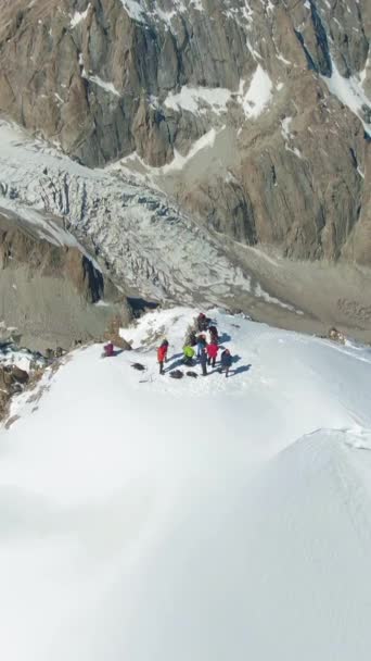 Άνθρωποι Στην Κορυφή Του Χιονισμένου Βουνού Στη Ηλιόλουστη Μέρα Αεροφωτογραφία — Αρχείο Βίντεο