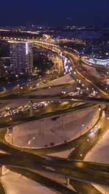 Kış Gecesinde Karmaşık Yol Kavşağı ve Araba Trafik Aydınlandı. Drone yükseliyor, Kamera Eğiliyor. Hava Hızı Hareketi. Drone Hiper Hata. Dikey Video