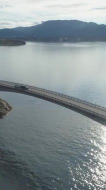 Araba Storseisundet Köprüsü 'nde. Norveç 'te Atlantik Okyanusu Yolu. Hava görüntüsü. Drone yörüngede dönüyor, Kamera aşağı eğiliyor. Dikey Video