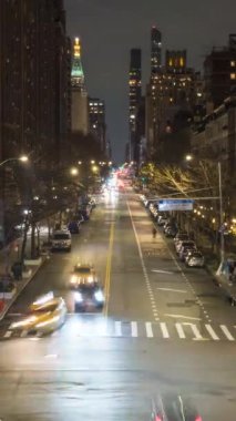 Manhattan 'da gece vakti araba trafiği. New York 'ta. 10. Cadde ve 23. Cadde kavşağı. Amerika Birleşik Devletleri. High Line Park 'tan görüntü. Zaman aşımı. Dikey Video