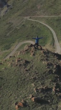 Yükselmiş Elli Yürüyüşçü, Güneşli Yaz Günü 'nde Dağ Zirvesi' nin tepesinde duruyor. Drone yörüngede dönüyor. Hava görüntüsü. Atış ayarlanıyor. Kırgızistan. Dikey Video