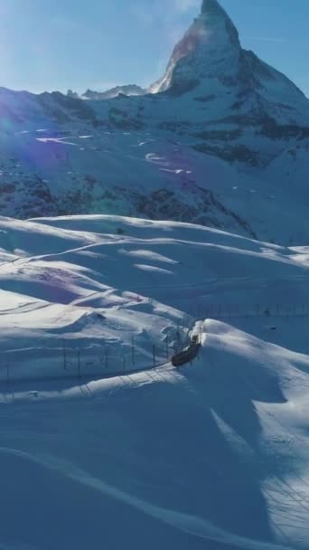 マッターホルン山と晴れた冬の日にトレイン スイスアルプス スイス アリアルビュー ショットを明らかに ドローン フライが向かって カメラがタイルを張る バーティカルビデオ — ストック動画