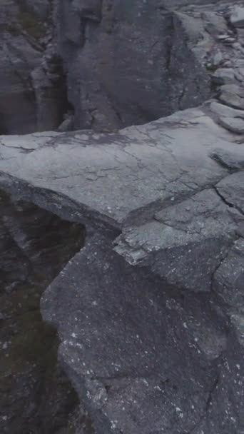 ノルウェーのトロルトゥンガ山クリフ 夏のトロール トンガ ロック アリアルビュー ドローンが周りを周回している カメラが傾いている スポットライトショット バーティカルビデオ — ストック動画