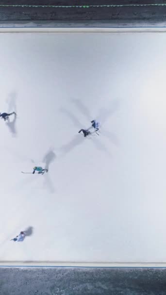 アイスリンクでアイスホッケーをする 空中垂直トップダウンビュー 静的ドローンショット バーティカルビデオ — ストック動画
