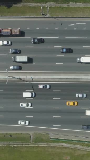 阳光明媚的夏日 汽车在城市的高速公路上行驶 空中垂直自上而下的视图 无人机是飞向左边的小道 设立射击 垂直录像 — 图库视频影像
