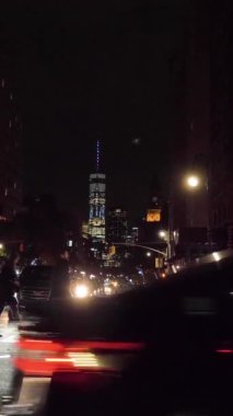 NEW YORK CITY, ABD - 20 Kasım 2018: Geceleyin Aşağı Manhattan 'da yaya geçidinde araba ve insanlar. Kentsel Şehir Manzarası. Steadicam shot, Crossroad 'a doğru yan yana hareket ediyor. Ağır çekim. Dikey Video