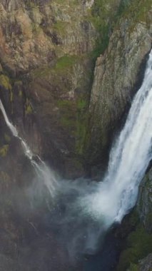 Voringfossen Şelalesi ve Cliff, Norveç 'te sonbahar gününde. Havadan Yukarıdan Aşağı Görünümü. Drone ileri ve yukarı uçuyor, Kamera aşağı eğiliyor. Dikey Video