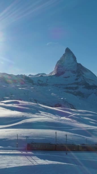 マッターホルン マウンテンとコッグ鉄道が晴れた冬の日 スイスアルプス スイス アリアルビュー ドローン フライズ サイドウェイ バーティカルビデオ — ストック動画
