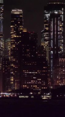 Manhattan Urban Skyline, Gece. New York 'ta. Sudan Manzara. Kamera yukarı egildi. Orta boy shot. Dikey Video