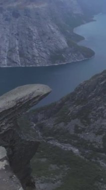 Norveç 'teki Trolltunga Kayalıkları. Yazın ünlü Trol Dili Rock 'ı. Hava görüntüsü. Drone etrafta uçuyor. Dikey Video
