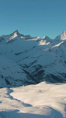 Kışın Karlı Dağlar. İsviçre Alpleri, İsviçre. Hava görüntüsü. Şutu göster. Drone geriye doğru uçuyor. Dikey Video